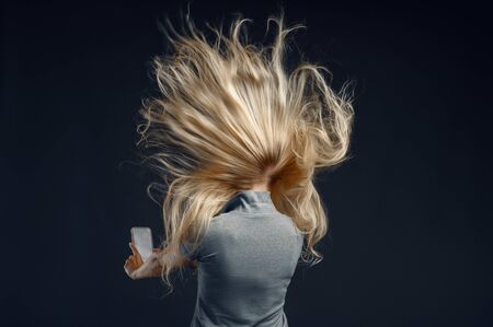 Woman standing against powerful airflow, back viewの写真素材