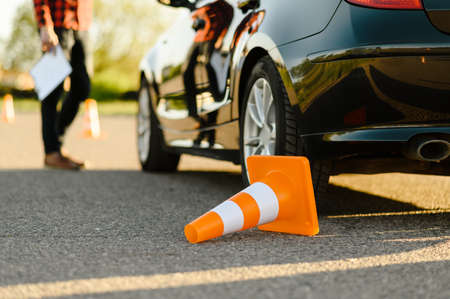 Male instructor at the car, downed traffic coneの写真素材