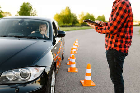 Instructor with checklist and woman in car, examの写真素材