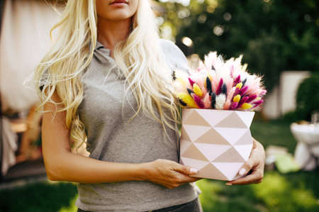 Tea party, woman holds basket with field flowersの写真素材