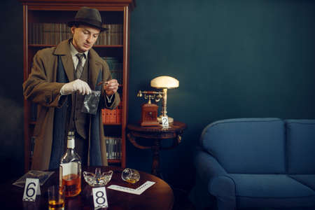 Detective puts the evidence in a bag, crime scene