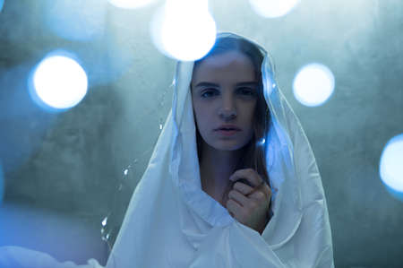 Mad woman in garlands sitting in bed, insomnia