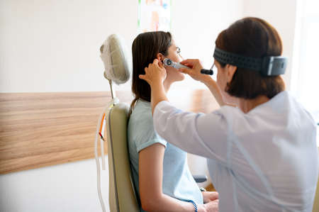 Female ent doctor and patient in office, ear exam