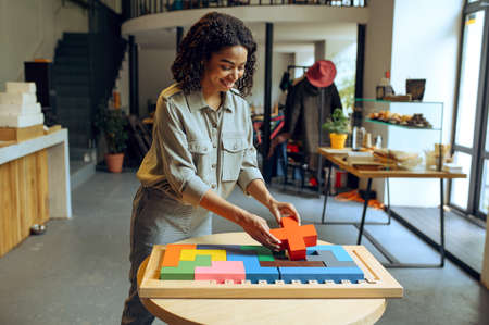 Cheerful female student finish the puzzle in cafe