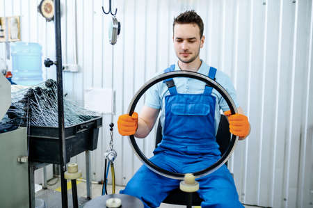 Worker holds new aluminum bicycle rim on factory