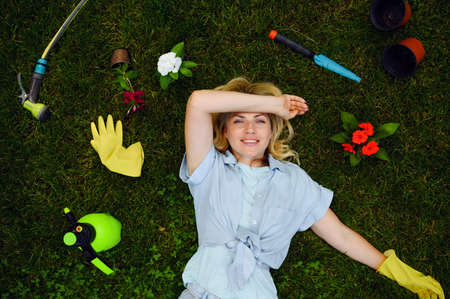 Woman lying on the grass in the garden, gardeningの写真素材