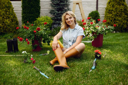 Female gardener sitting on the grass in the garden
