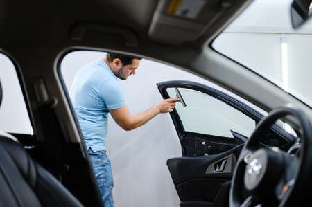 Male wrapper installs car tinting, tuning service