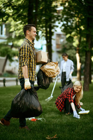 Man holds plastic trash bags in park, volunteeringの写真素材
