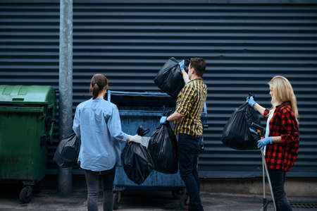 Volunteers puts plastic trash bags into the canの写真素材