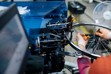 Worker installs bicycle rim on factory, closeupの写真素材