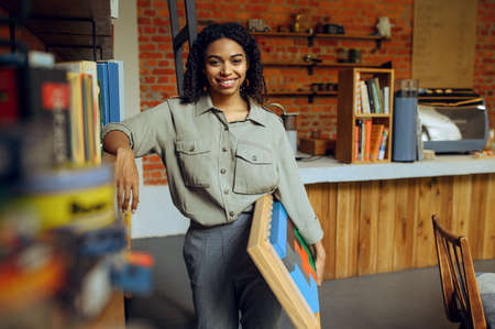 Female student poses at the shelf in libraryの写真素材
