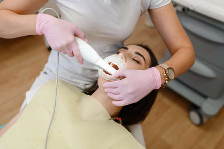 Female dentist works with patient tooth in clinicの写真素材