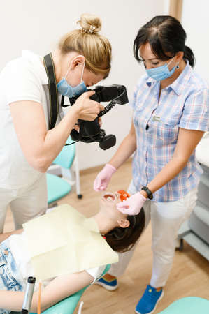 Female orthodontist, assistant and patient, clinic