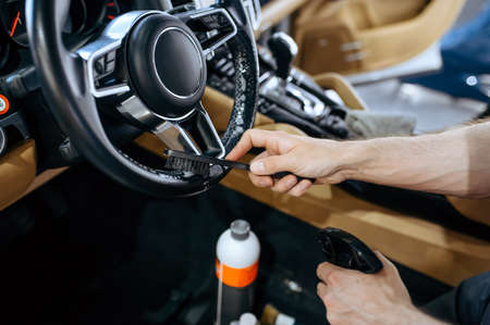 Worker wipes car steering wheel, detailingの写真素材