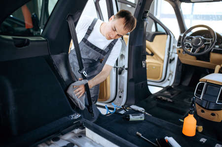 Worker with rag wipes car interior plasticの写真素材