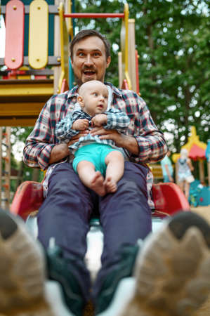 Happy parents play with little baby on playgroundの写真素材