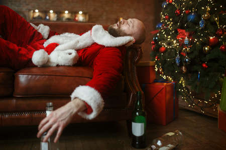Bad drunk Santa claus sleeps on sofa after partyの写真素材