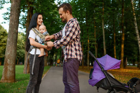 Parents and little baby walking along the alley