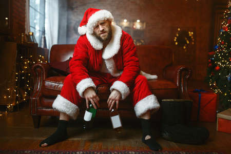 Bad Santa claus celebrate christmas with bottleの写真素材
