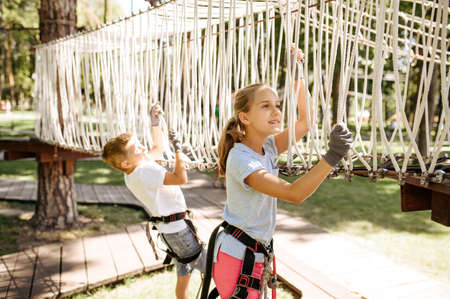 Little brave kids climbs on net in rope parkの写真素材