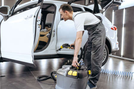 Worker with vacuum cleaner, car dry cleaningの写真素材