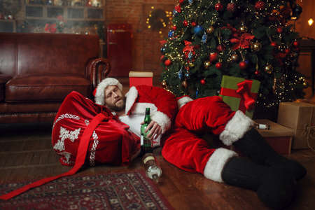 Bad drunk Santa claus sleeps under christmas treeの写真素材