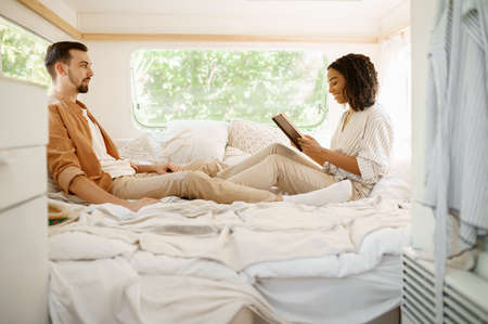Love couple relax in bedroom, camping in a trailerの写真素材
