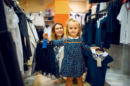Mother and little baby choosing skirt, kids storeの写真素材