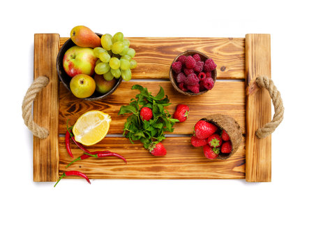 Vegetables, fruits and berries on wooden boardの写真素材