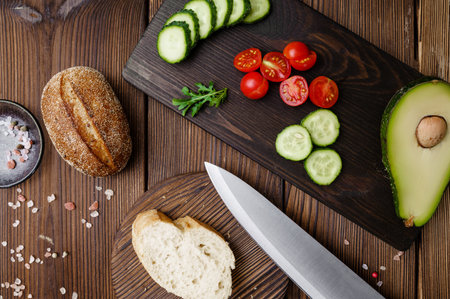 Cutted tomatoes and cucumbers, wooden backgroundの写真素材