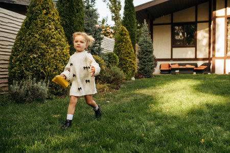 Little cheerful kid running in the gardenの写真素材