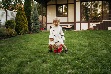 Kid play with dog in garden, caring for animals