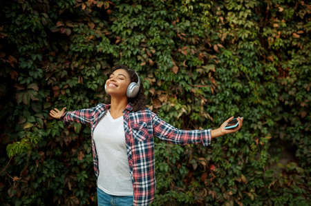 Woman in headphones listening to music in parkの写真素材