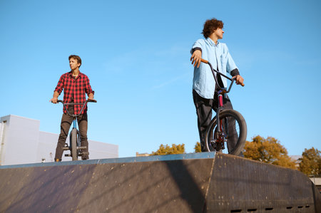 Bmx biker standing on ramp, training in skateparkの写真素材