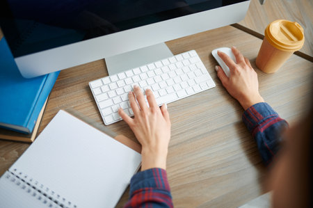 Female IT specialist hands on keyboard in officeの写真素材