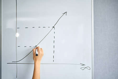 Female IT specialist draws a graph on the boardの写真素材