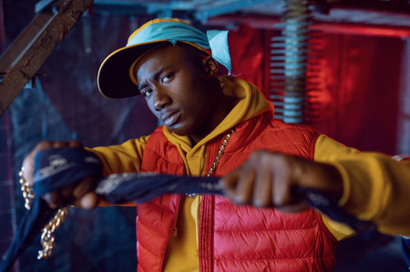 Stylish rapper in yellow hoodie posing in studioの写真素材