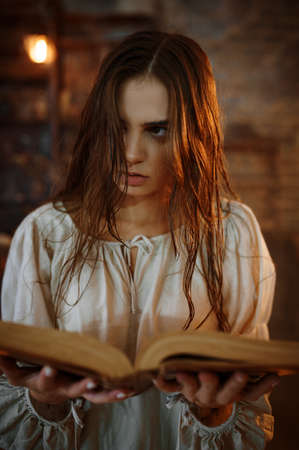 Young demonic woman holds book of spellsの写真素材