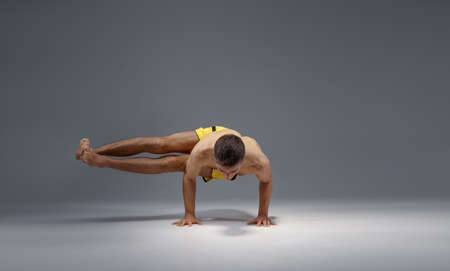 Muscular yoga stands on hands in difficult poseの写真素材