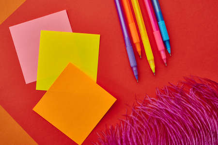 Pens and notepads closeup, red background