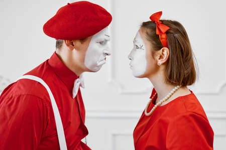 Mime artists in red costumes look at each otherの写真素材