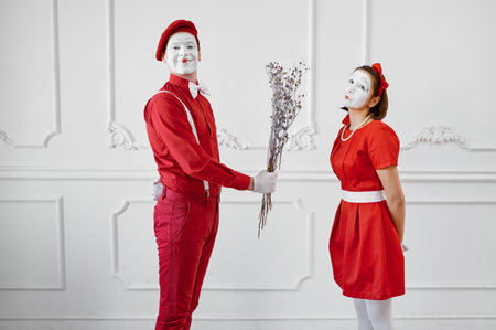 Mime artists in red costumes, scene with bouquetの写真素材