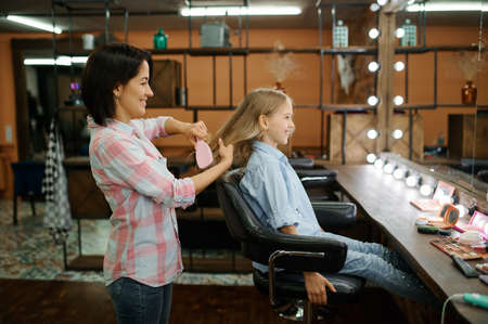 Mother and daughter do their hair in salonの写真素材
