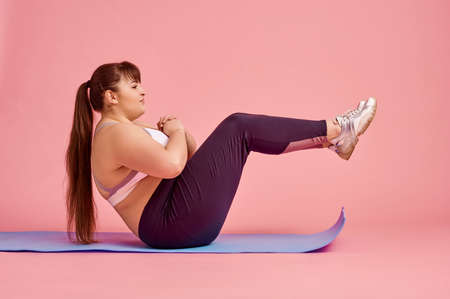Overweight woman doing abs exercise, body positiveの写真素材