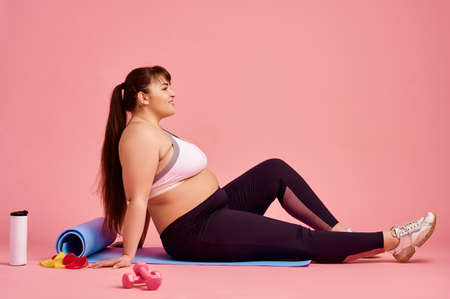 Overweight woman doing abs exercise, body positiveの写真素材