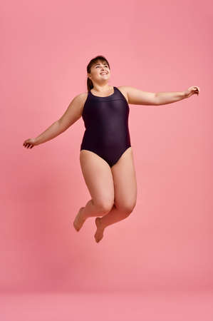 Overweight woman in swimsuit jumps, body positiveの写真素材