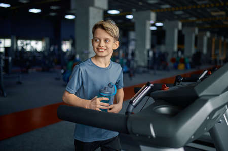 Boy doing exercise on treadmill, running machine