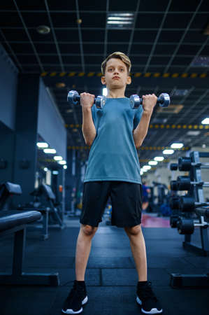 Boy doing exercise with dumbbells, bottom viewの写真素材