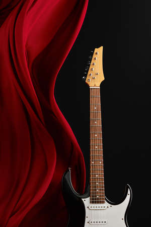 Black electric guitar, red curtain, nobodyの写真素材